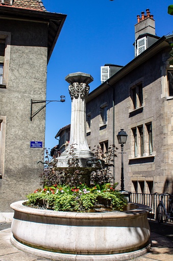 A vertical shot of a historical fountain in Rue Jean Calvin, Geneva, Switzerland
