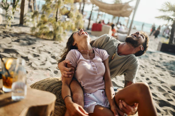 istock Cheerful couple laughing on the beach. 1446832406