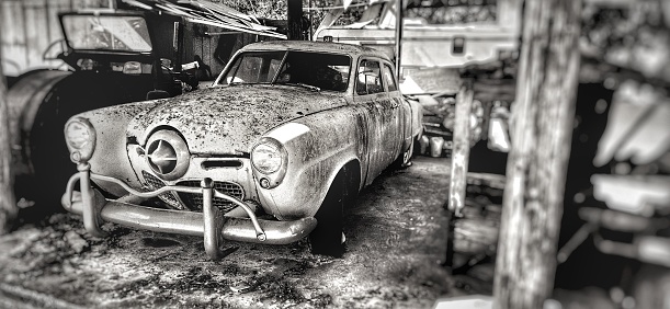 Tampa, United States – November 26, 2022: A rusty old Studebaker champion car model in a greyscale.