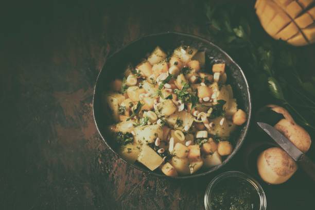 Delicious potato with mango, nuts and pesto in pan
