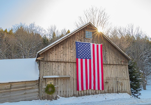 new England barn in Vermont in the winter time with American flag