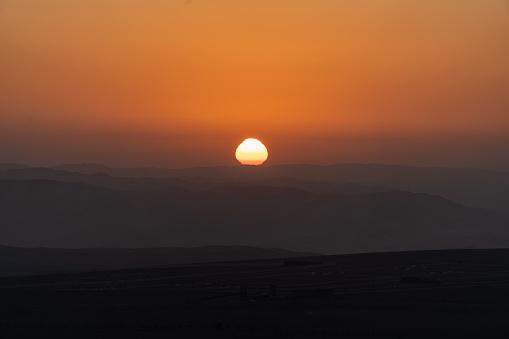 A beautiful shot of a sunset over a sandy desert near Huacachina