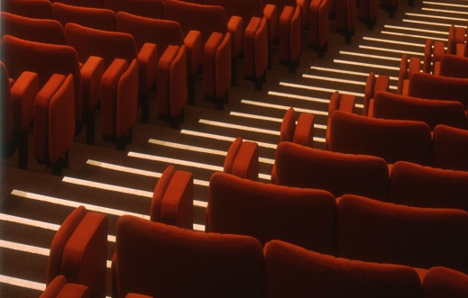 The empty red chairs in a movie theater