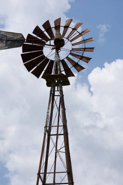 istock Low angle shot of vintage windmill on field under blue cloudy sky 1446841676