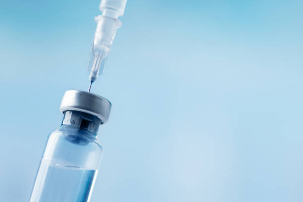 istock Glass vial and syringe with injection over blue background. 1446843576