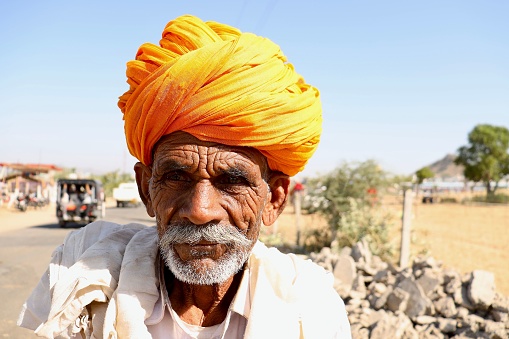 Rajasthan, India – November 06, 2022: A headshot portrait of a Rajasthani or Marwadi old man in the regional attire, wearing turban(pagdi).