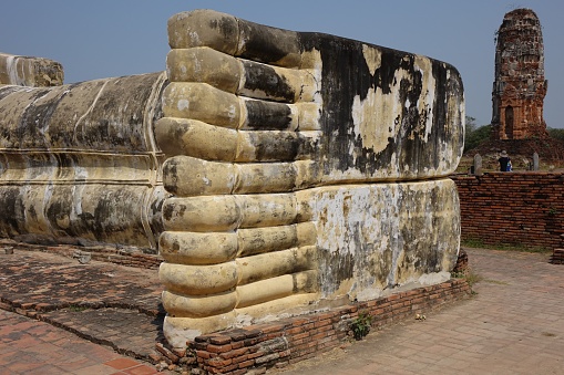 A close-up shot of the reclining Buddha statue ruins in Ayutthaya, Thail