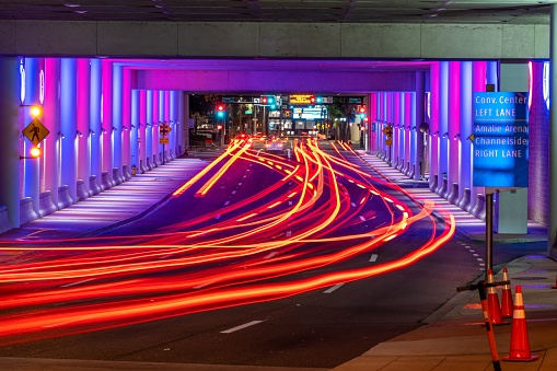 The long exposure shot of the light trails along the road in the tunnel
