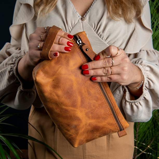 istock Handmade leather makeup bag on a woman's hands 1446848436