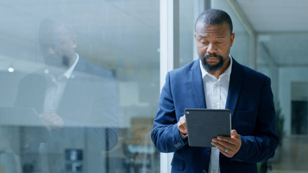 Business, tablet and black man on corporate website, social networking or software technology app. Digital productivity, email and african businessman reading chat notification and walking in office negocios, tableta y hombre negro en el sitio web corporativo, redes sociales o aplicación de tecnología de software. productividad digital, correo electrónico y hombre de negocios africano leyendo notificaciones de chat y caminando en la oficina