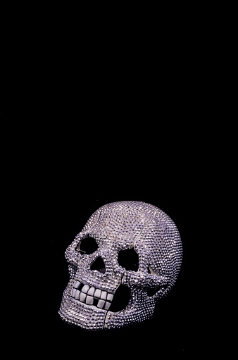 A diamond skull with broken teeth on a black background