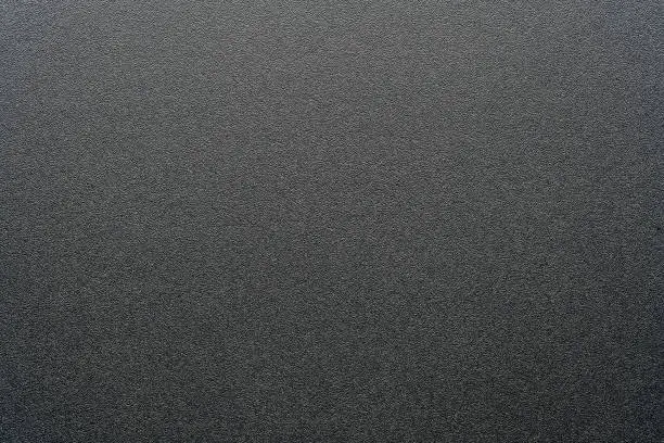 Photo of Rough black plastic background and texture. Black plastic material, closeup