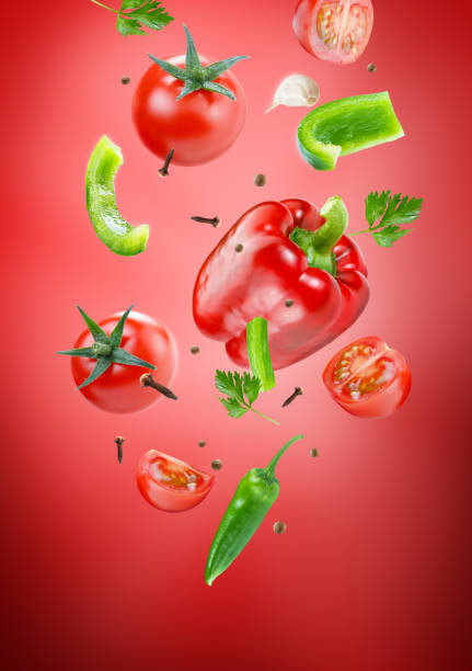istock red pepper with tomatoes in group flying on air stream on dark red background 1446850885