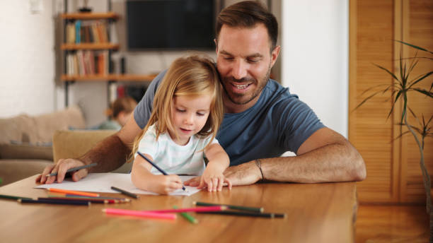 istock Father and daughter having good time drawing at home together 1446858194