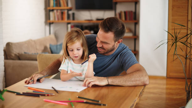 istock Father and daughter having good time drawing at home together 1446858230