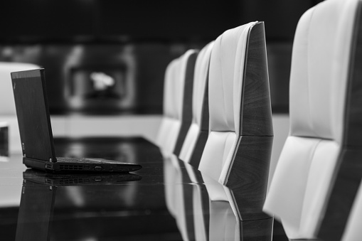 Empty meeting room with laptop on table, black and white effect