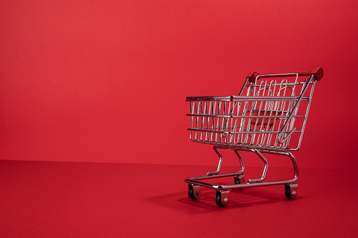An small toy shoping cart on a red background