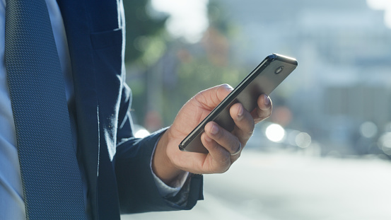 Phone, communication and navigation with a man in the city using an app to hail a taxi for transportation. Smartphone, networking and GPS with a male in an urban town searching for travel application