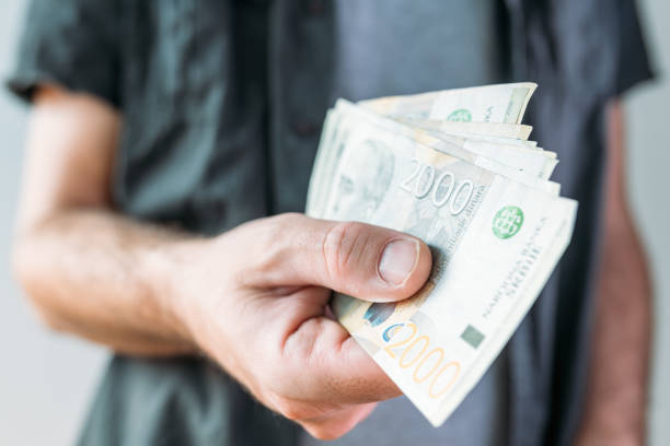 istock Man holding Serbian currency Dinar paper banknotes 1446866730