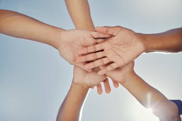 istock Hands, teamwork and collaboration, blue sky and low angle of baseball people working together for target, goal or mission. Trust, support or motivation of sports group in solidarity, unity or union. 1446867580