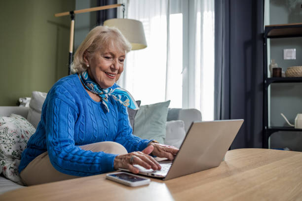 istock Senior woman using a laptop at home 1446868008