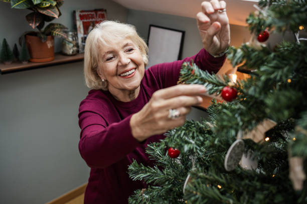 istock Senior woman decorating a Christmas tree 1446869031