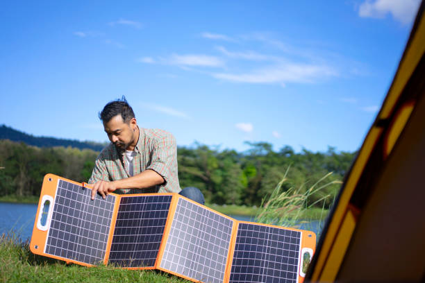 istock The man is camping outdoor and solar panel is charging battery. 1446869428