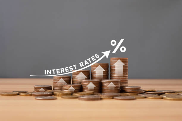 パーセンテージアイコンとイラスト付きの灰色の背景を持つテーブル上のコインの積み重ねは、金利/金融コンセプトの増加を示しています。 - interest rate ストックフォトと画像