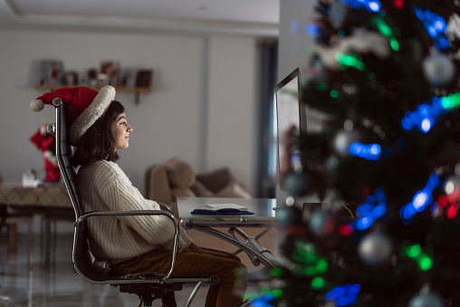 girl on christmas day chooses her gifts online. Screen with editable white background