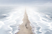 istock Illustration of man walking in the beach between two blue seas, surreal abstract path concept 1446872644