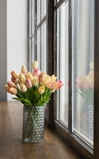 Bouquet of flowers by window, high key, in glass jar with copy space. Bright and airy in modern farmhouse kitchen