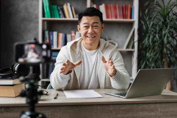 istock Asian man vlogging in home office 1446873544