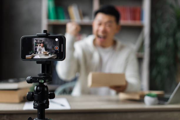 istock Asian man vlogging in home office 1446873655