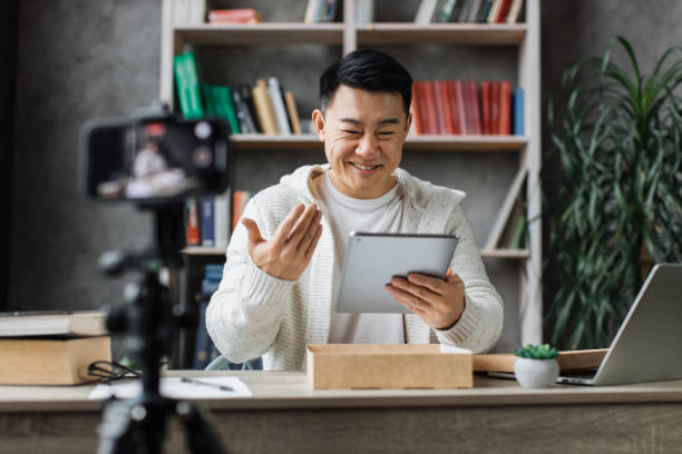 istock Asian man vlogging in home office 1446873661