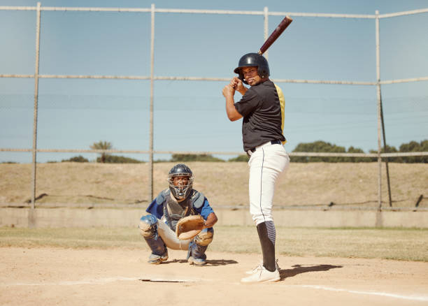 istock Baseball, pitcher and man with a bat on pitch playing a match or sport training as a team. Fitness, sports and men athletes practicing pitching and batting before a softball game on an outdoor field. 1446873901