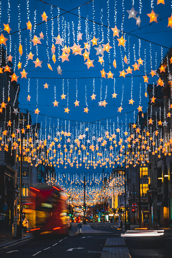 View of a colourful decorated festive Christmas decoration and holiday lights at night in Oxford Circus in Central London, England, UK N