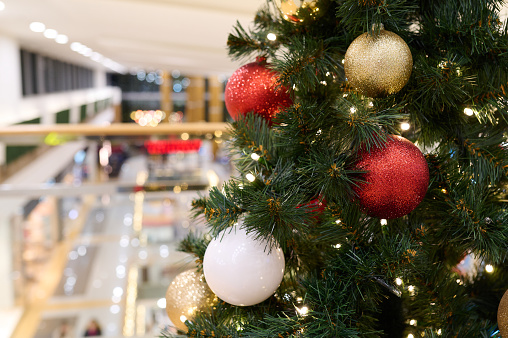 Christmas tree with gold decoration in shopping mall closeup