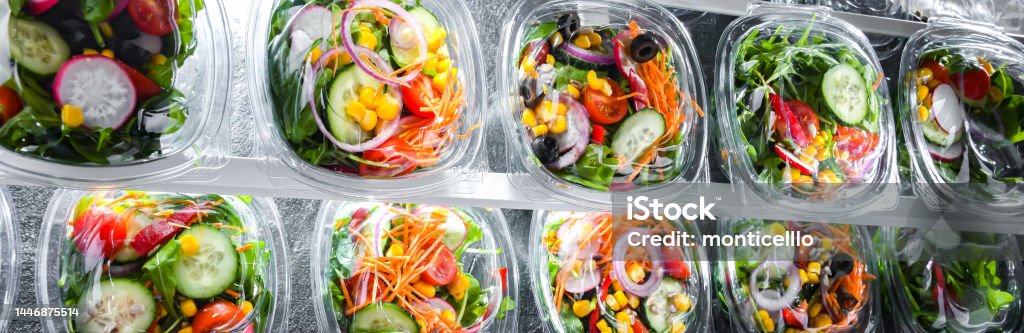 Boxes with pre-packaged vegetable salads in a commercial fridge Plastic boxes with pre-packaged vegetable salads, put up for sale in a commercial refrigerator Take Out Food Stock Photo