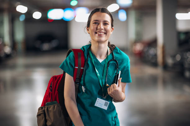 Going home after a long day A young Caucasian female nurse is looking at the camera with a warm smile. She's wearing a uniform and a stethoscope around her neck. medic stock pictures, royalty-free photos & images