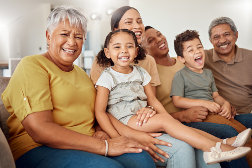 Grandparents, parents and children being happy, smile or laugh on sofa in living room for bonding, embrace or for loving. Family, mother or father with kids for happiness, together or on lounge couch