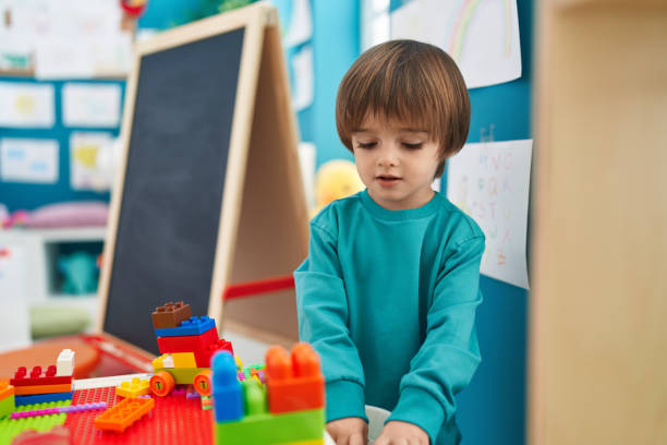 istock Adorable toddler playing with construction blocks standing at kindergarten 1446878454