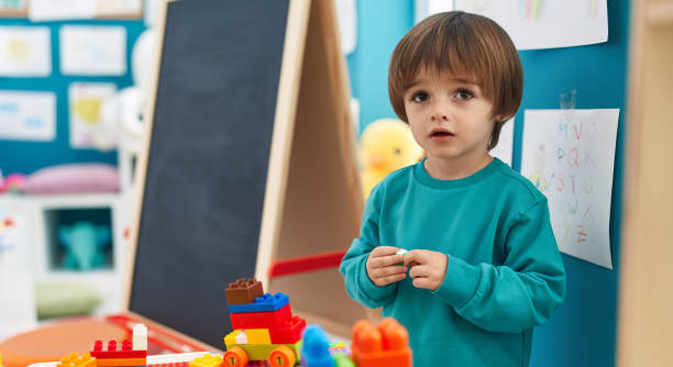 istock Adorable toddler playing with construction blocks standing at kindergarten 1446878496