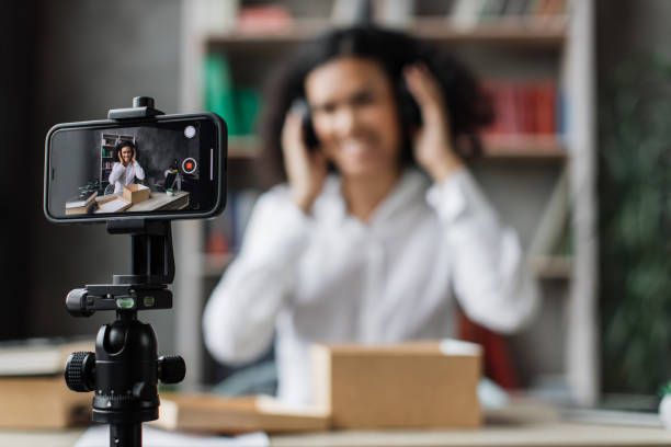 concéntrese en la pantalla del teléfono inteligente, la mujer grabando video en la caja de desembalaje del teléfono con auriculares nuevos - freight transportation audio fotografías e imágenes de stock