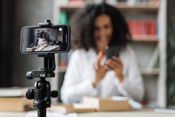 istock Focus on smart phone screen, pleasant multinational woman opening parcel box with new smartphone 1446878592