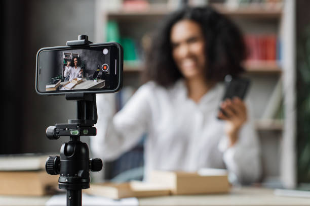 istock Focus on smart phone screen, pleasant multinational woman opening parcel box with new smartphone 1446878603