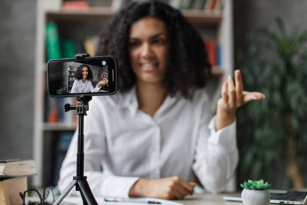 istock Charming multinational woman talking and gesturing while recording video on modern phone. 1446878641