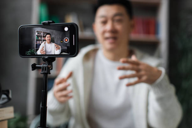 istock Charming multinational woman talking and gesturing while recording video on modern phone. 1446878673