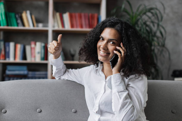 istock Cheerful young lady in casual wear talking on smartphone while resting on comfy couch. 1446878735