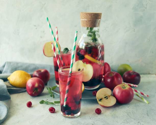detox drink from apples, berries, mint and citrus in glasses and in a decanter, on the table, seasonal drinks from organic natural ingredients - healthy eating food and drink nutrition label food imagens e fotografias de stock