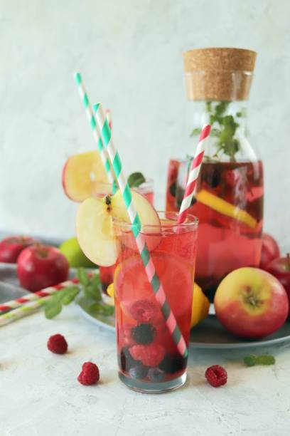 detox drink from apples, berries, mint and citrus in glasses and in a decanter, on the table, seasonal drinks from organic natural ingredients - healthy eating food and drink nutrition label food imagens e fotografias de stock